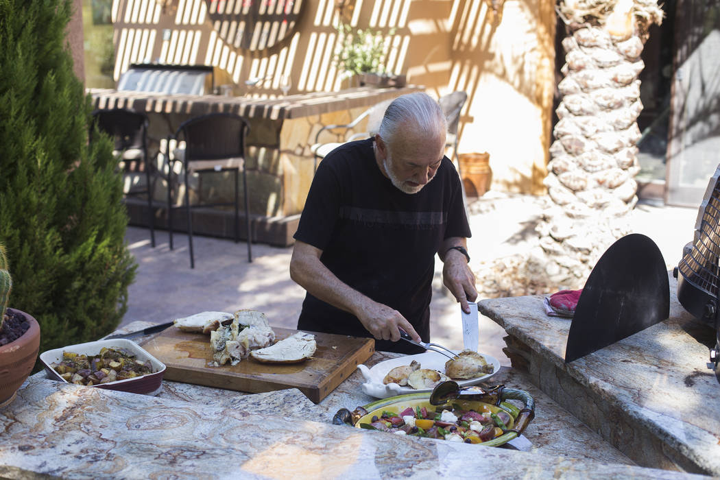 Hubert Keller, chef of Fleur de Lys and Fleur, cuts a rotisserie chicken in his backyard kitche ...