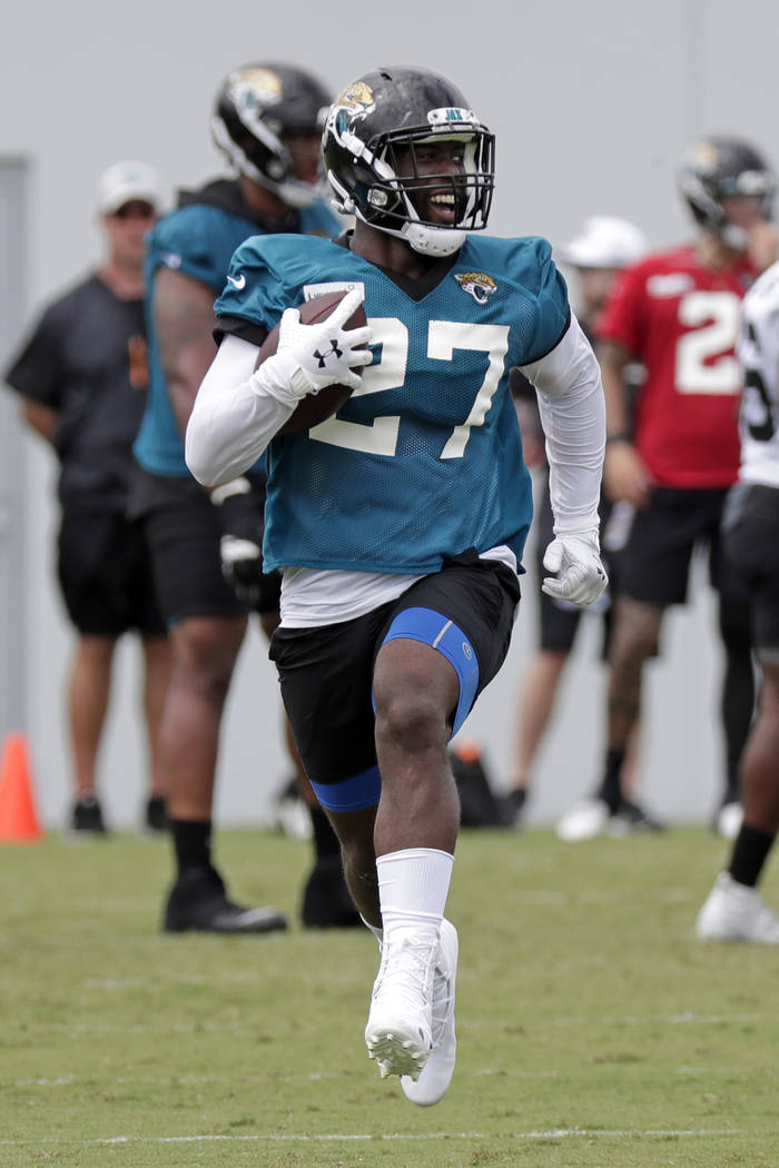 Jacksonville Jaguars running back Leonard Fournette (27) runs with the ball during an NFL footb ...