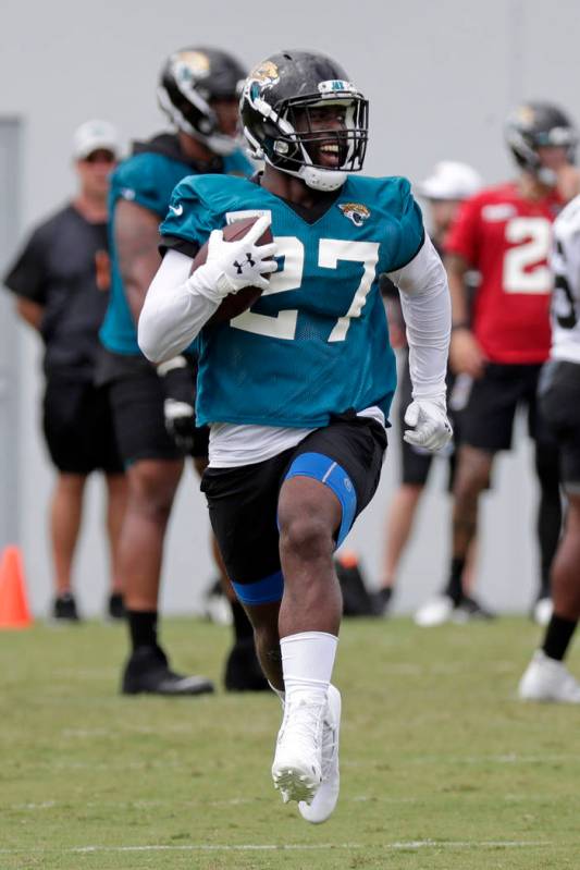 Jacksonville Jaguars running back Leonard Fournette (27) runs with the ball during an NFL footb ...