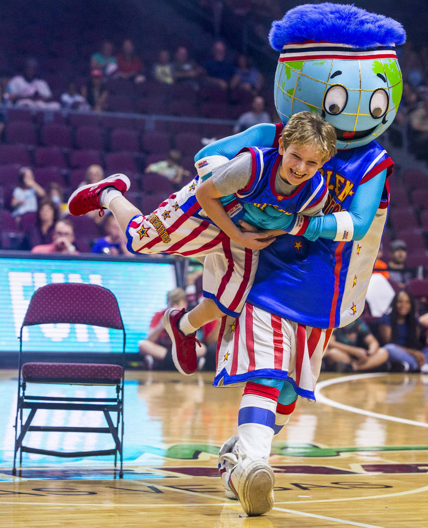 Mascot Globie, right, carries off fan Ethan Cohen, 10, while playing musical chairs as the Harl ...