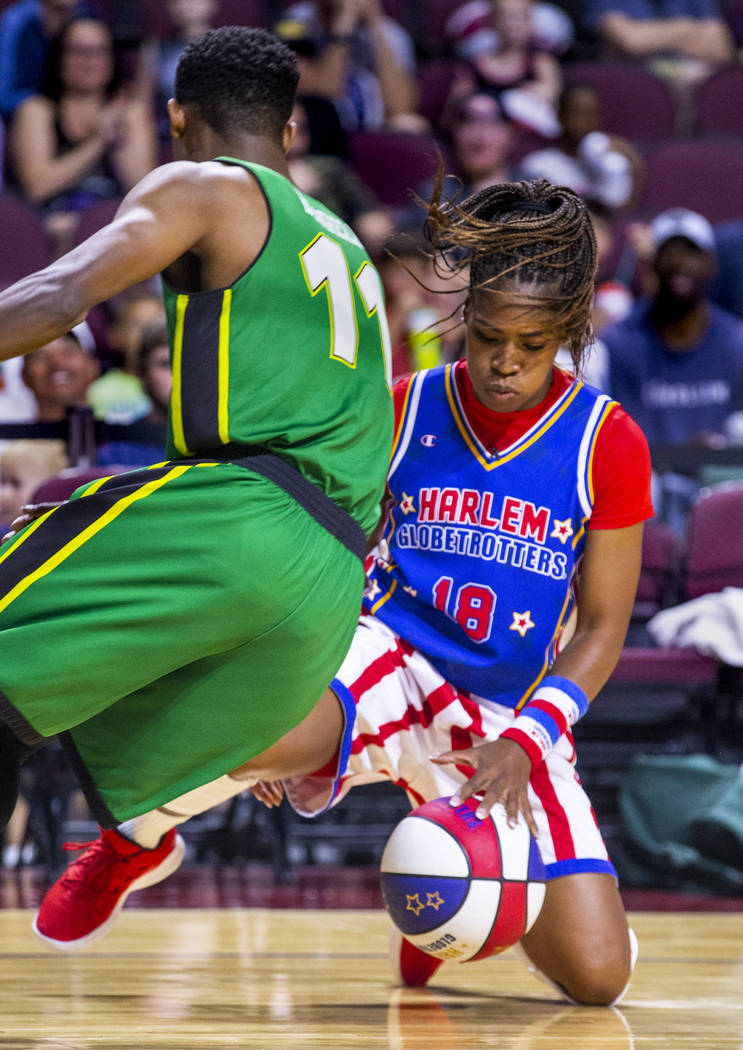 Harlem Globetrotter TNT Lister (18, right) dribbles the basketball through her legs around the ...