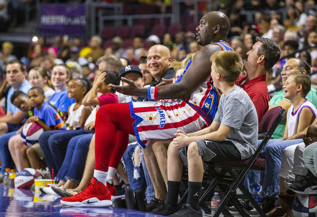 Harlem Globetrotter Big Easy Lofton (52) sits on the lap of a fan while joking around for the c ...