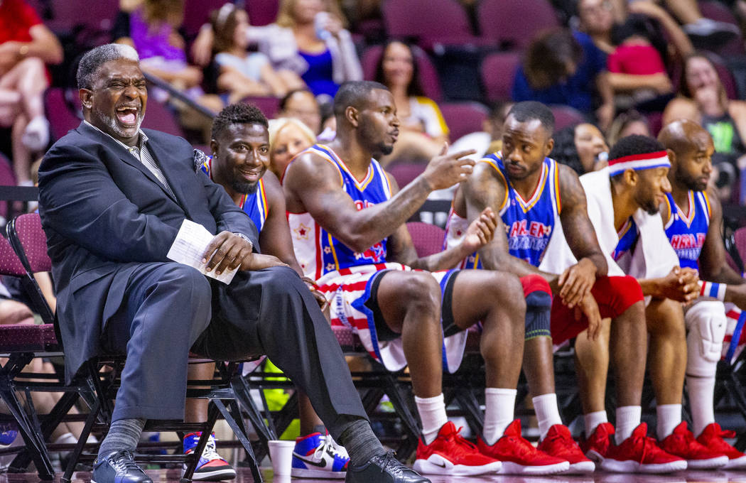 Harlem Globetrotters head coach Sweet Lou Dunbar, left, enjoys a laugh on the bench with guest ...