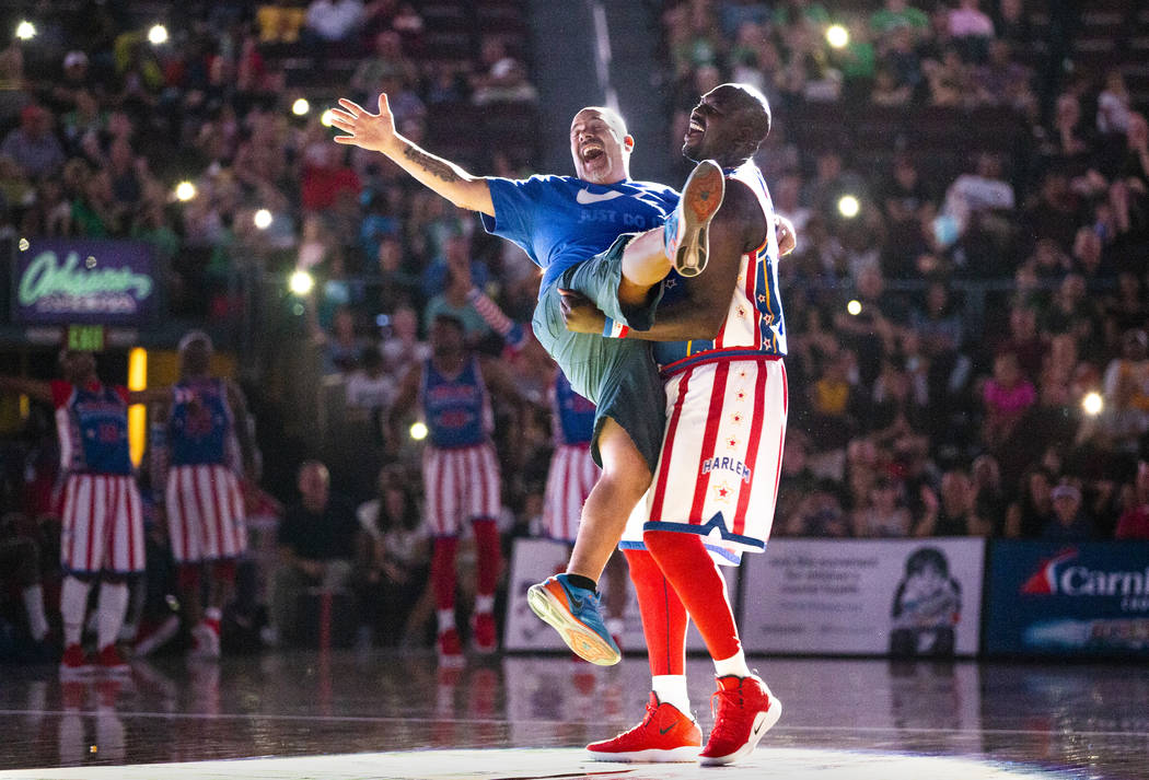 Harlem Globetrotter Big Easy Lofton (52, right) dances under a spotlight with fan Frank Perone ...