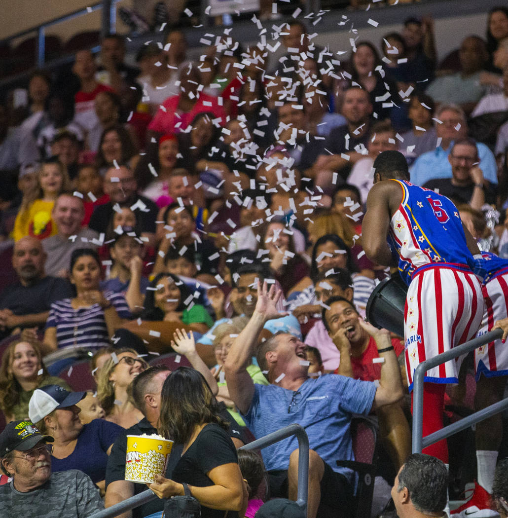 Harlem Globetrotter Bulldog Mack (5) throws a bucket of paper on the crowd pretending it was wa ...