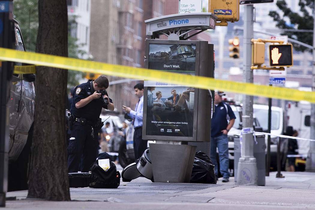 An investigator photographs a suspicious package that was thought to be an explosive device in ...