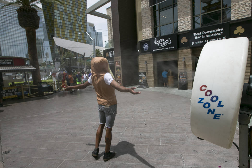 A man in a hot dog bun costume cools off in front of a misting fan on the Las Vegas Strip. (Las ...