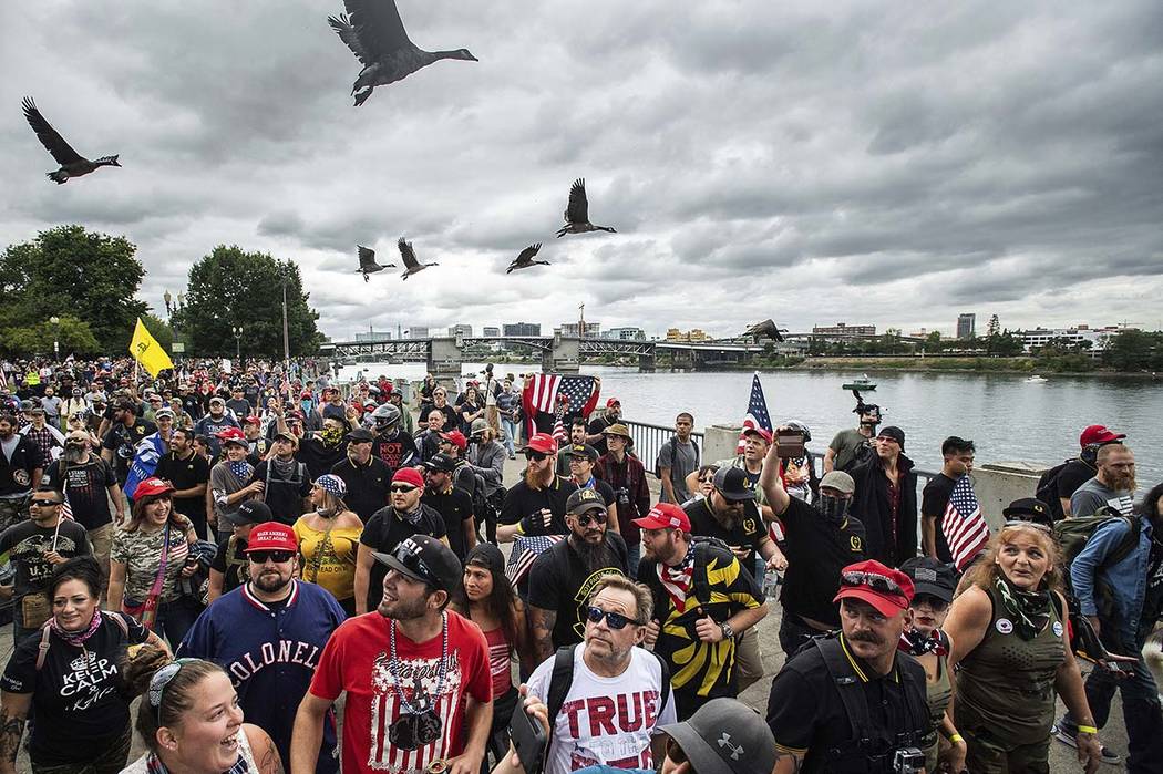 Members of the Proud Boys and other right-wing demonstrators march along the Willamette River d ...