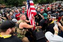 Joseph Oakman and fellow Proud Boys plant a flag in Tom McCall Waterfront Park during an " ...