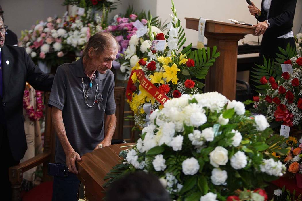 Antonio Basco, companion of Margie Reckard, leans on her casket during her funeral at La Paz Fa ...