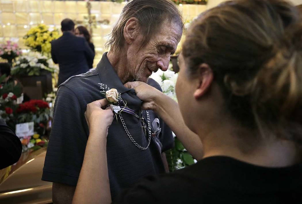 Antonio Basco has a flower pinned to his shirt at the funeral of his companion of 22 years, Mar ...