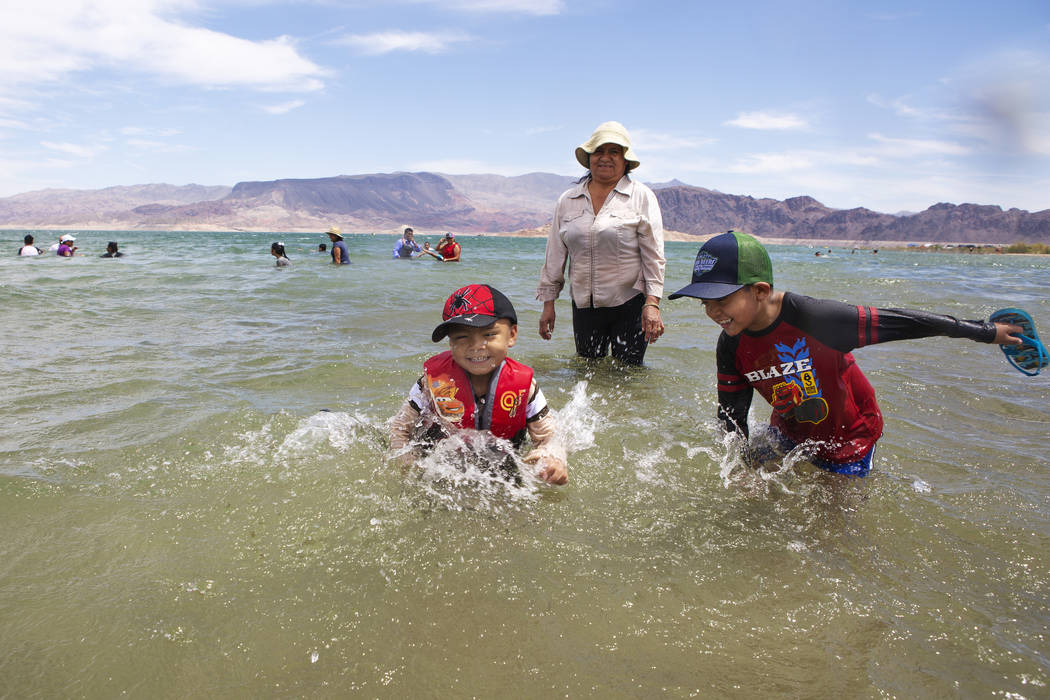 Jaiden Sanchez, 4, left, and his brother Jason, 7, right, splash in the water as their aunt Noe ...