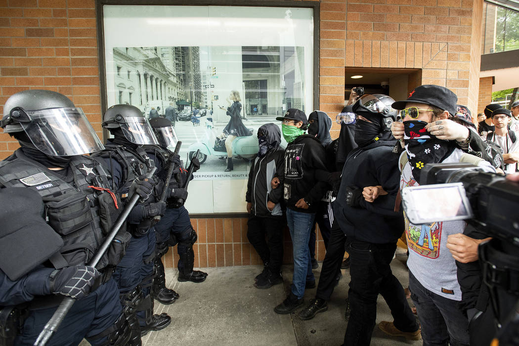 Police officers face off against protesters opposed to right-wing demonstrators following an &q ...