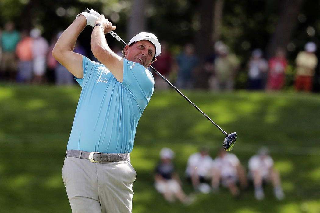 Phil Mickelson watches his tee shot on the 18th hole during the second round of the BMW Champio ...