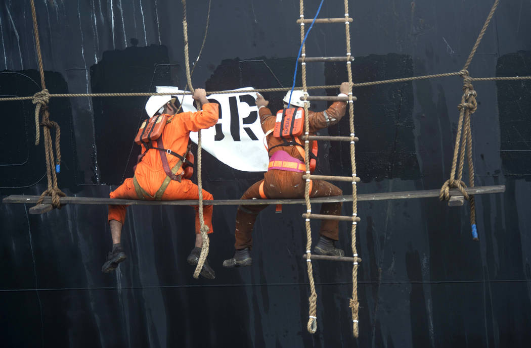 Crew members of the Grace 1 super tanker remove the name of ship in the British territory of Gi ...