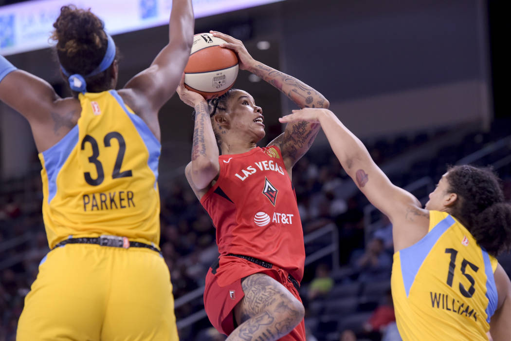 Las Vegas Aces' Tamera Young takes a shot over the Chicago Sky's Cheyenne Parker (32) and Gabby ...