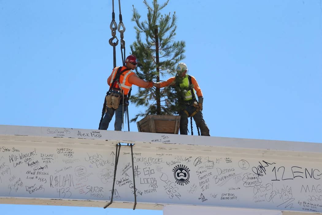 Workers shake hands after hoisting the last high beam on top of the future Las Vegas Convention ...