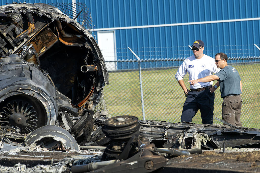 Members of the National Transportation Safety Board looks at the wreckage of a plane that Dale ...