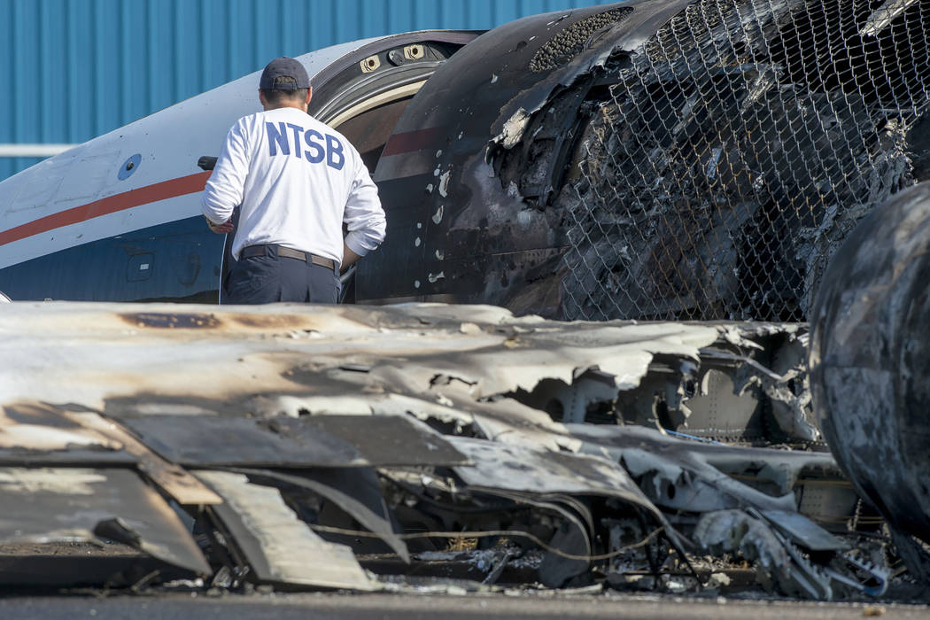 A member of the National Transportation Safety Board looks at the wreckage of a plane that Dale ...