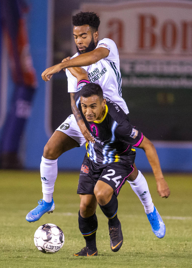 Las Vegas Lights FC forward Jose Villarreal (24) advances the ball while fighting off Portland ...