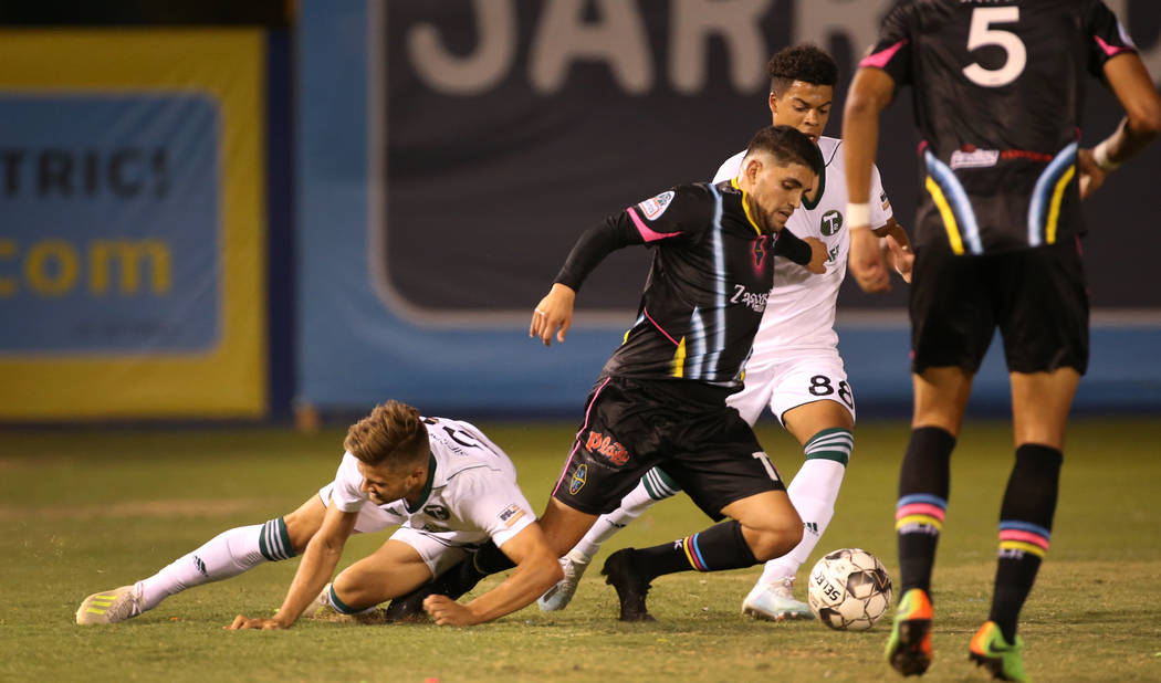 Las Vegas Lights FC forward Irvin Parra (11, center) is taken down by Portland Timbers 2 forwar ...