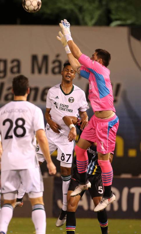 Las Vegas Lights FC goalkeeper Thomas Olsen (1, right) pulls in a header from a Portland Timber ...