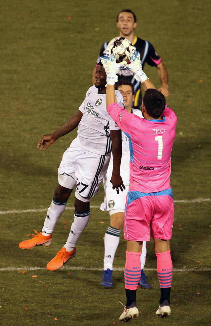 Las Vegas Lights FC goalkeeper Thomas Olsen (1, right) snatches the ball on a header attempt t ...