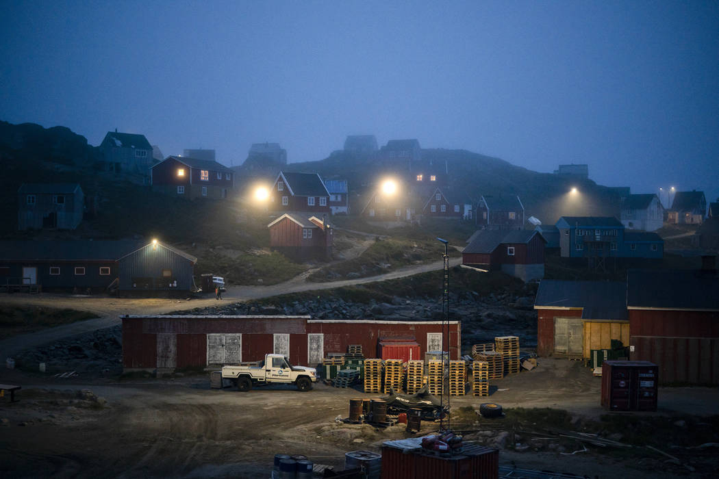 In this Aug. 15, 2019, photo, early morning fog shrouds homes in Kulusuk, Greenland. In tiny Ku ...