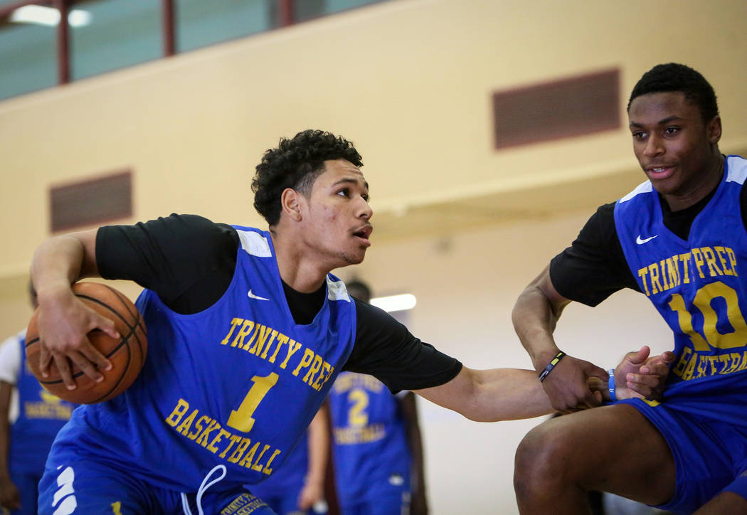 Trinity International junior Daishen Nix (1) drives against teammate Marlon Lestin during a pra ...