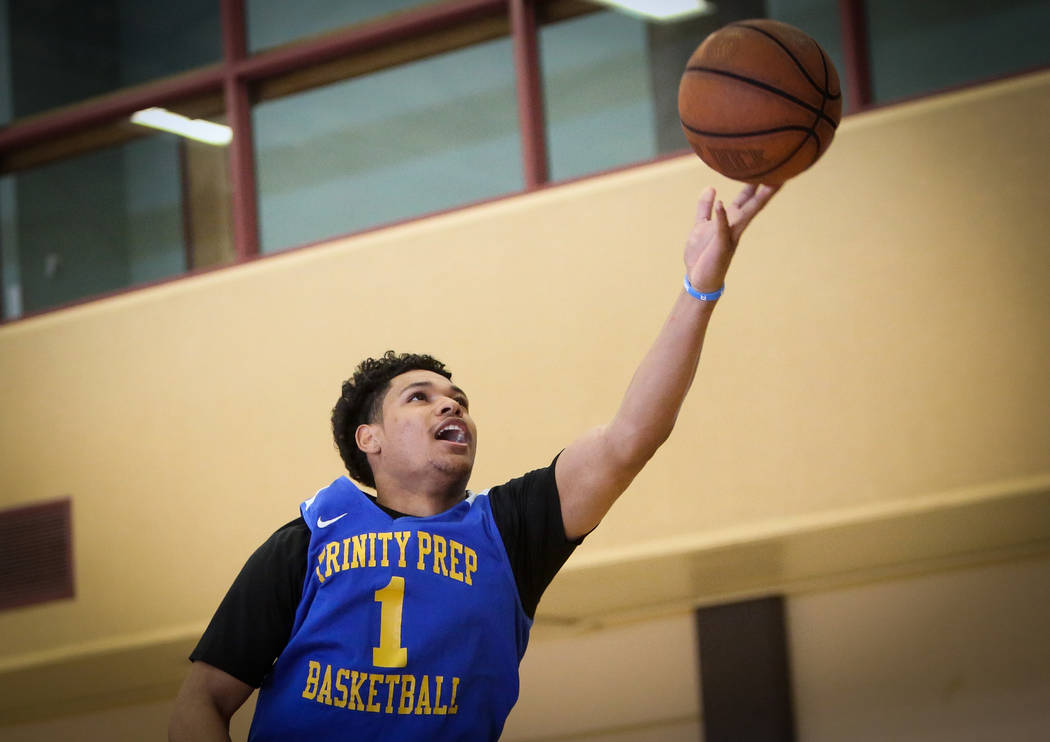 Trinity International junior Daishen Nix reaches for the ball during a practice at the Bill and ...