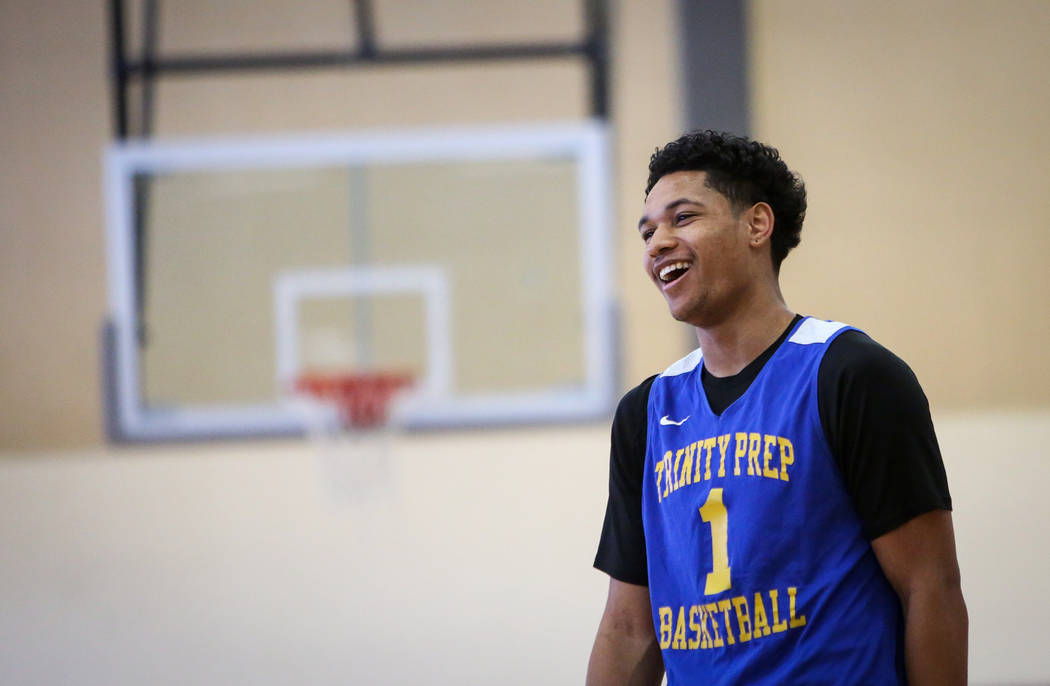 Trinity International junior Daishen Nix laughs while talking with his teammates during a pract ...