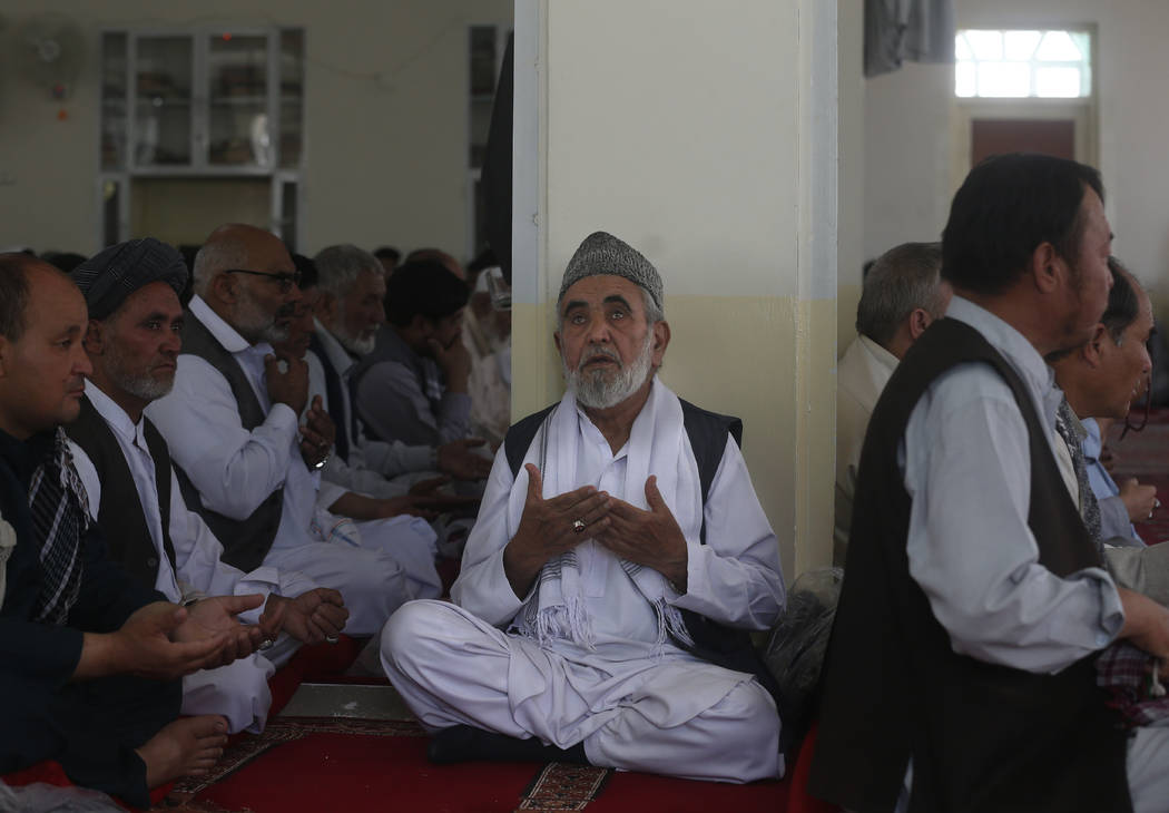 Afghan pray for the victims of the Dubai City wedding hall bombing during a memorial service at ...