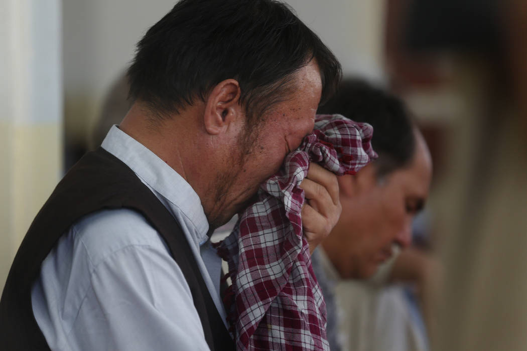 Men mourn for the victims of the Dubai City wedding hall bombing during a memorial service at a ...