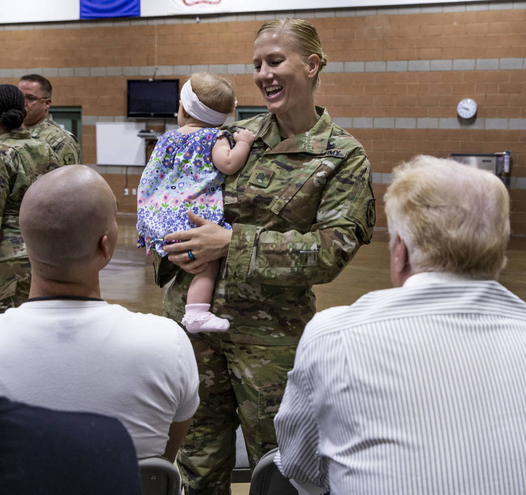Sgt. Jessica Done holds her daughter Rylie, 8-month-old, as she talks with family before a mobi ...