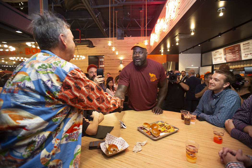 Shaquille O'Neal, center, greets guests during the grand opening celebration of Big Chicken, Sh ...