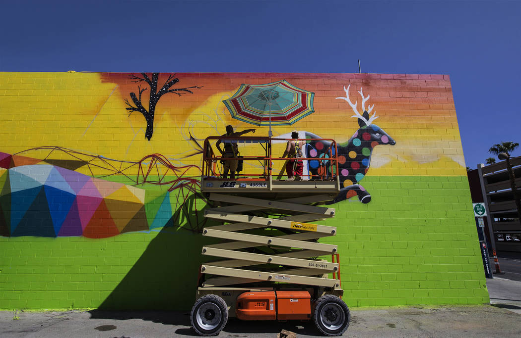 Artist Okuda San Miguel, left, works on a mural outside the Meow Wolf art motel on Monday, Sept ...