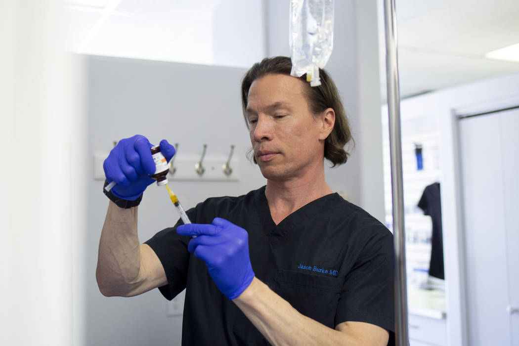 Dr. Jason Burke, founder of pioneering IV-therapy business Hangover Heaven, prepares IV fluids ...