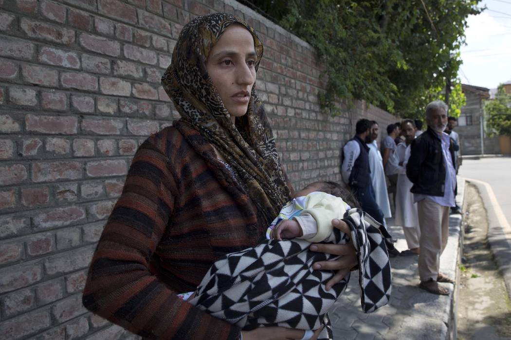 Ulfat, a Kashmiri woman holds her forty days old daughter Tanzeela, as she waits outside a poli ...