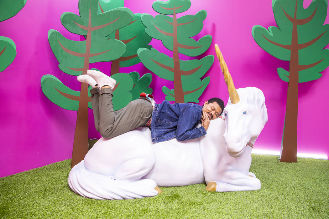 Chad Wilson snuggles up while in the Cornelius the Unicorn Room at the new Happy Place popup at ...