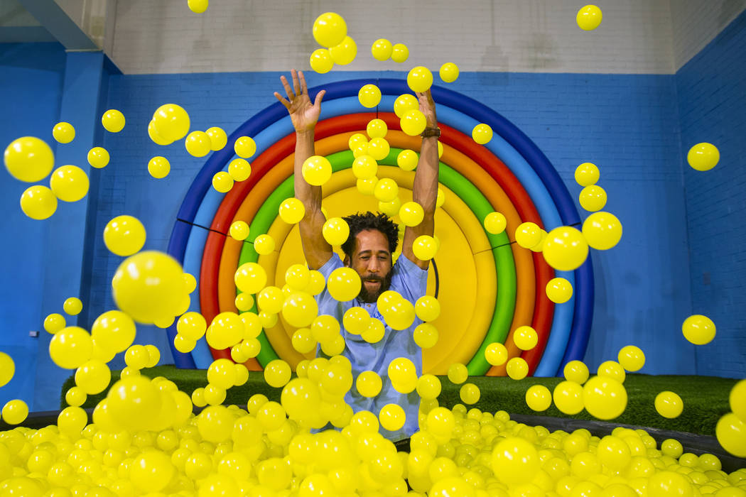 Bryce Hill pops up from the ball pit in the Pot of Happiness Room at the new Happy Place popup ...