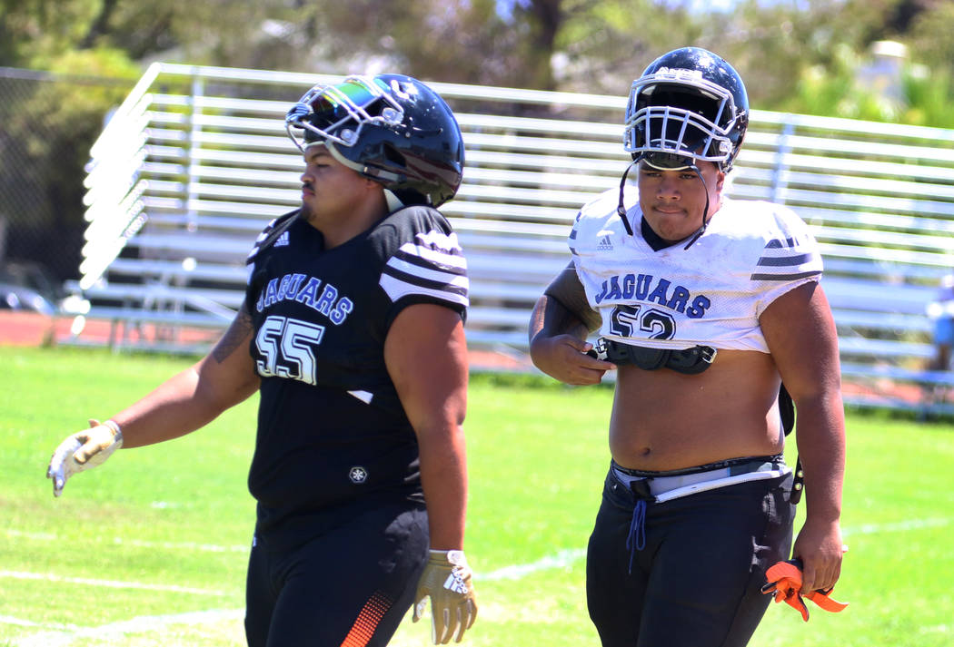 Desert Pines High School defensive linemen Blaze Homalon, left, and Fatafehi Vailea walk to the ...