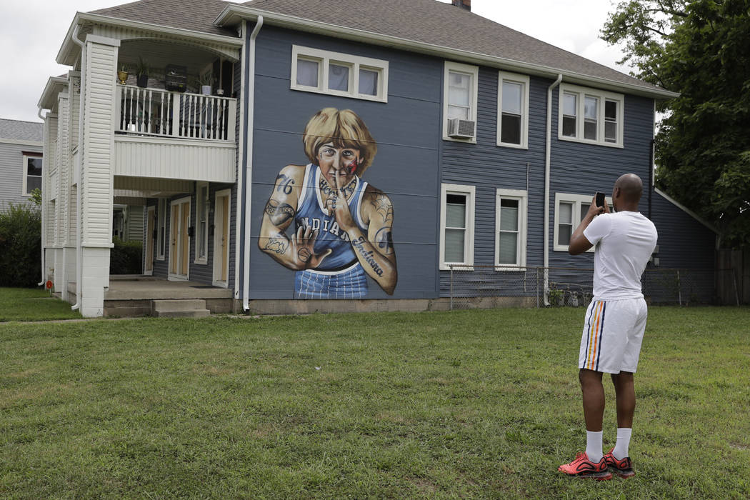 D'Andre Peyton takes a photo of a mural of former NBA star Larry Bird on the side of a multi-fa ...