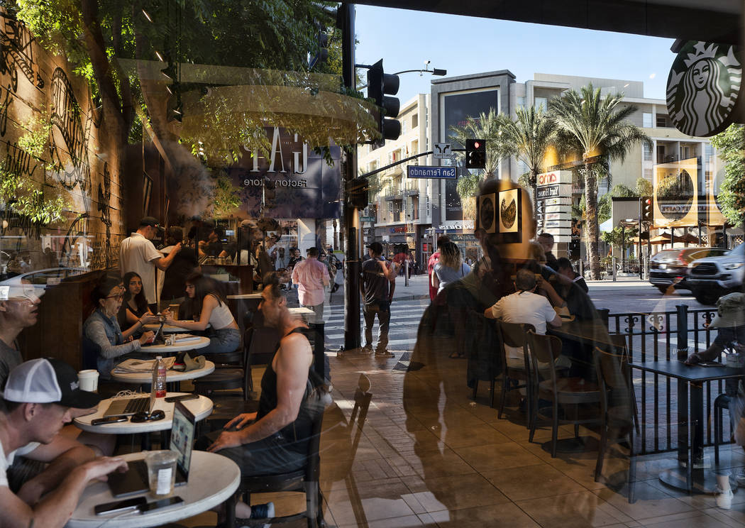 FILE - In this Aug. 8, 2019, file photo customers are seen through the window of a coffee shop ...