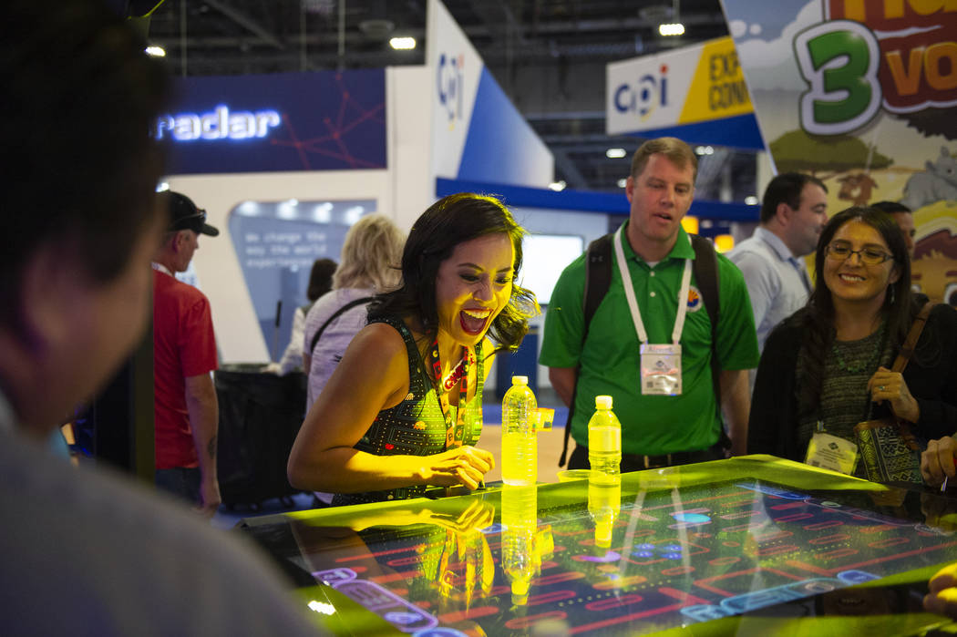 Nikki Tuazon shows attendees how to play the new Gamblit Pac-Man game at the 18th annual Global ...