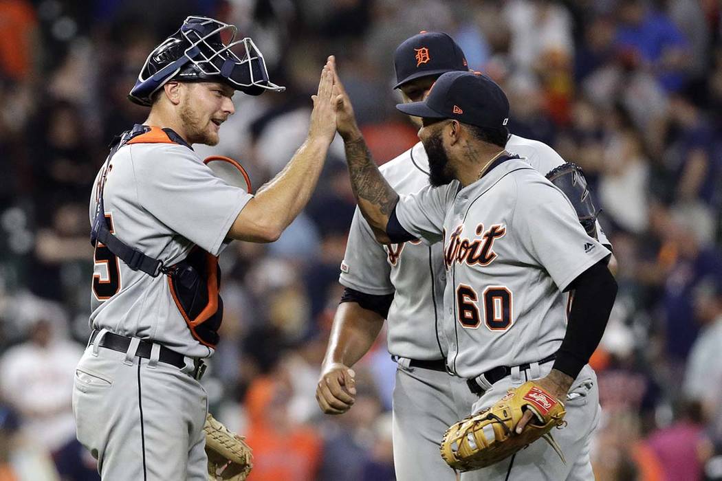 Detroit Tigers' John Hicks, left, celebrates with Ronny Rodriguez (60) and Joe Jimenez after a ...