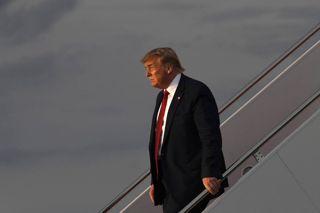 In this Aug. 21, 2019 photo, President Donald Trump walks down the steps of Air Force One at An ...