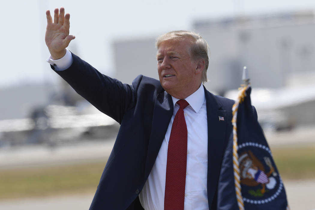 President Donald Trump waves to the crowd after arriving on Air Force One at Louisville Interna ...