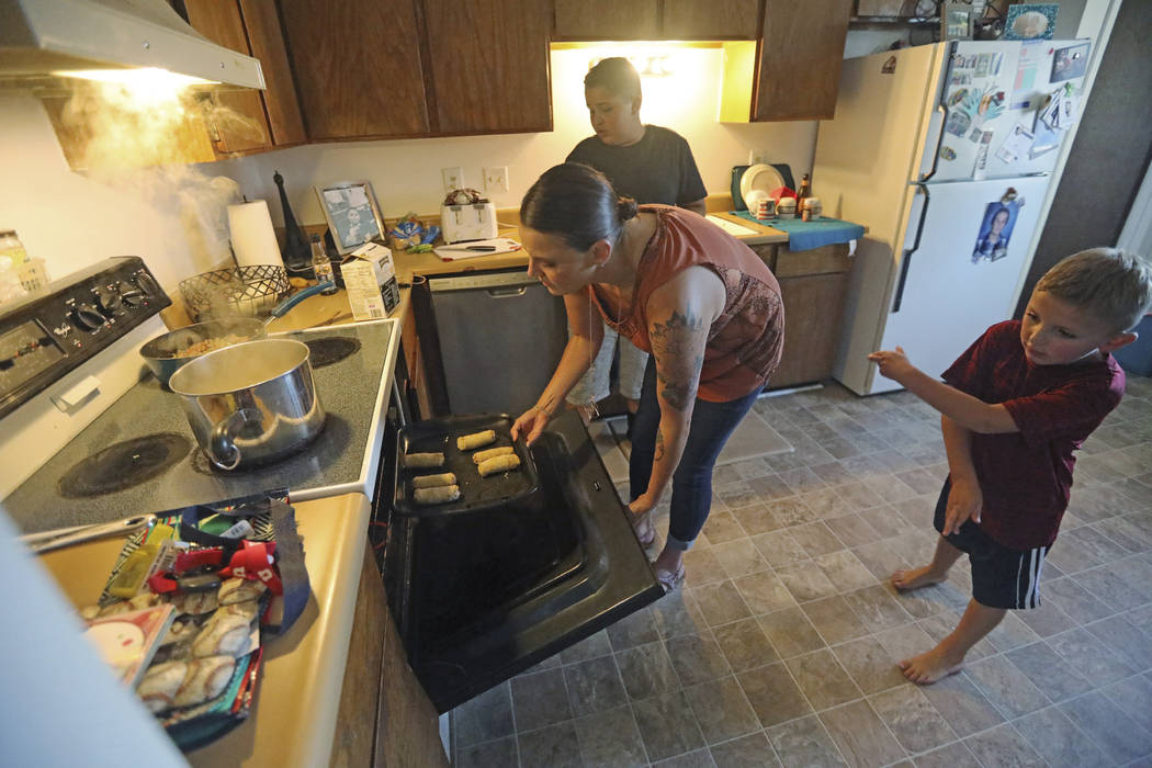 Misty Dotson prepares dinner for her son's at their home Tuesday, Aug. 20, 2019, in Murray, Uta ...