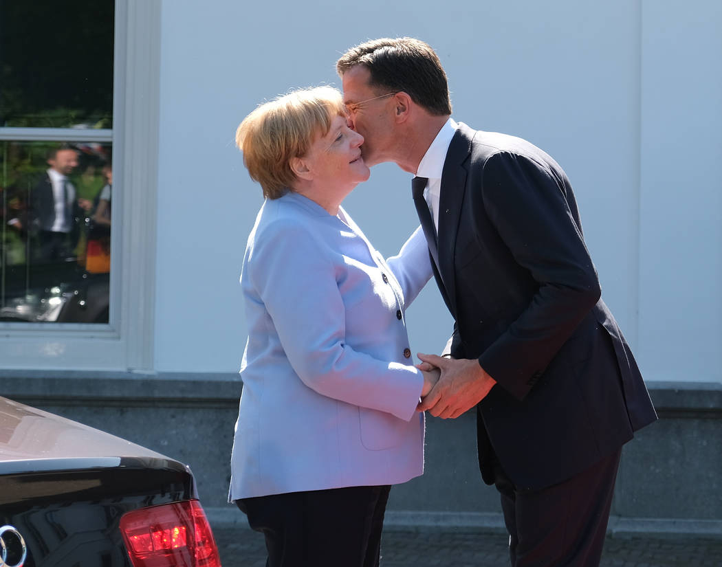 Dutch Prime Minister Mark Rutte, right, greets German Chancellor Angela Merkel in The Hague, Ne ...