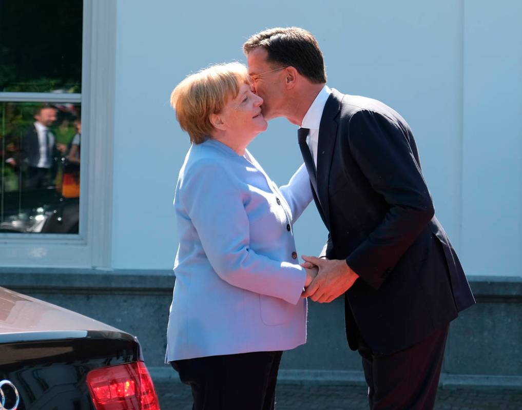 Dutch Prime Minister Mark Rutte, right, greets German Chancellor Angela Merkel in The Hague, Ne ...